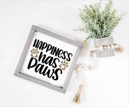 Happiness Has Paws wood sign with black lettering and paw prints, perfect for pet lovers.