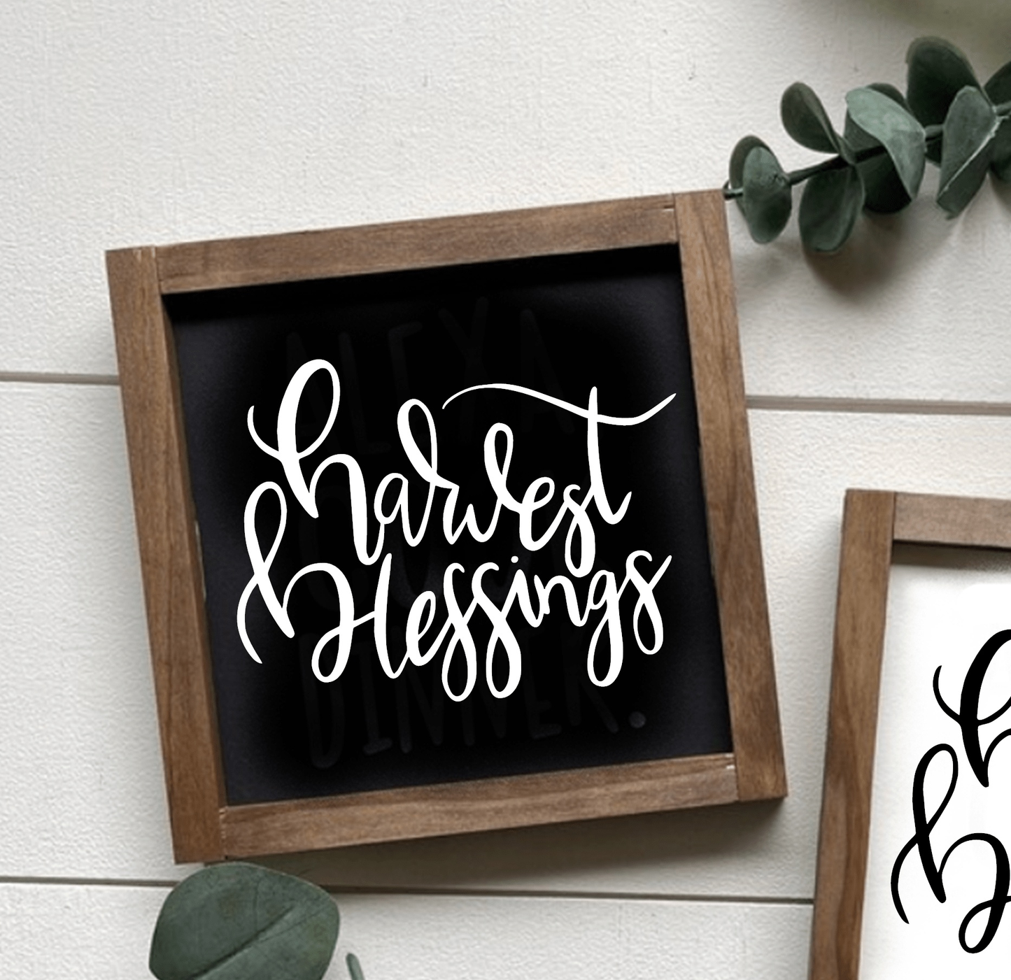 Framed wood sign with "Harvest Blessings" in white script on black background, rustic decor.