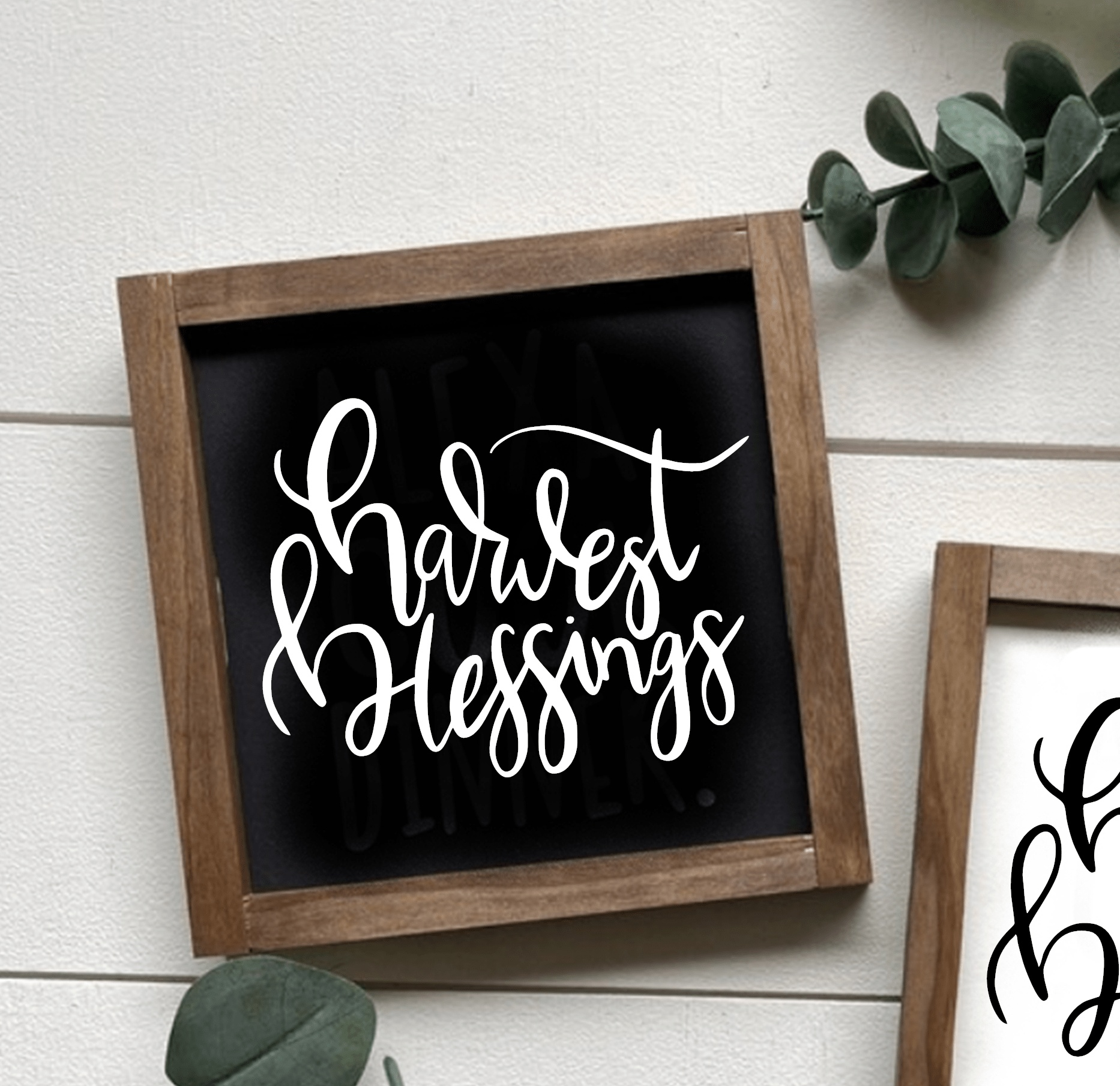Framed wood sign with "Harvest Blessings" in white script on black background, rustic decor.