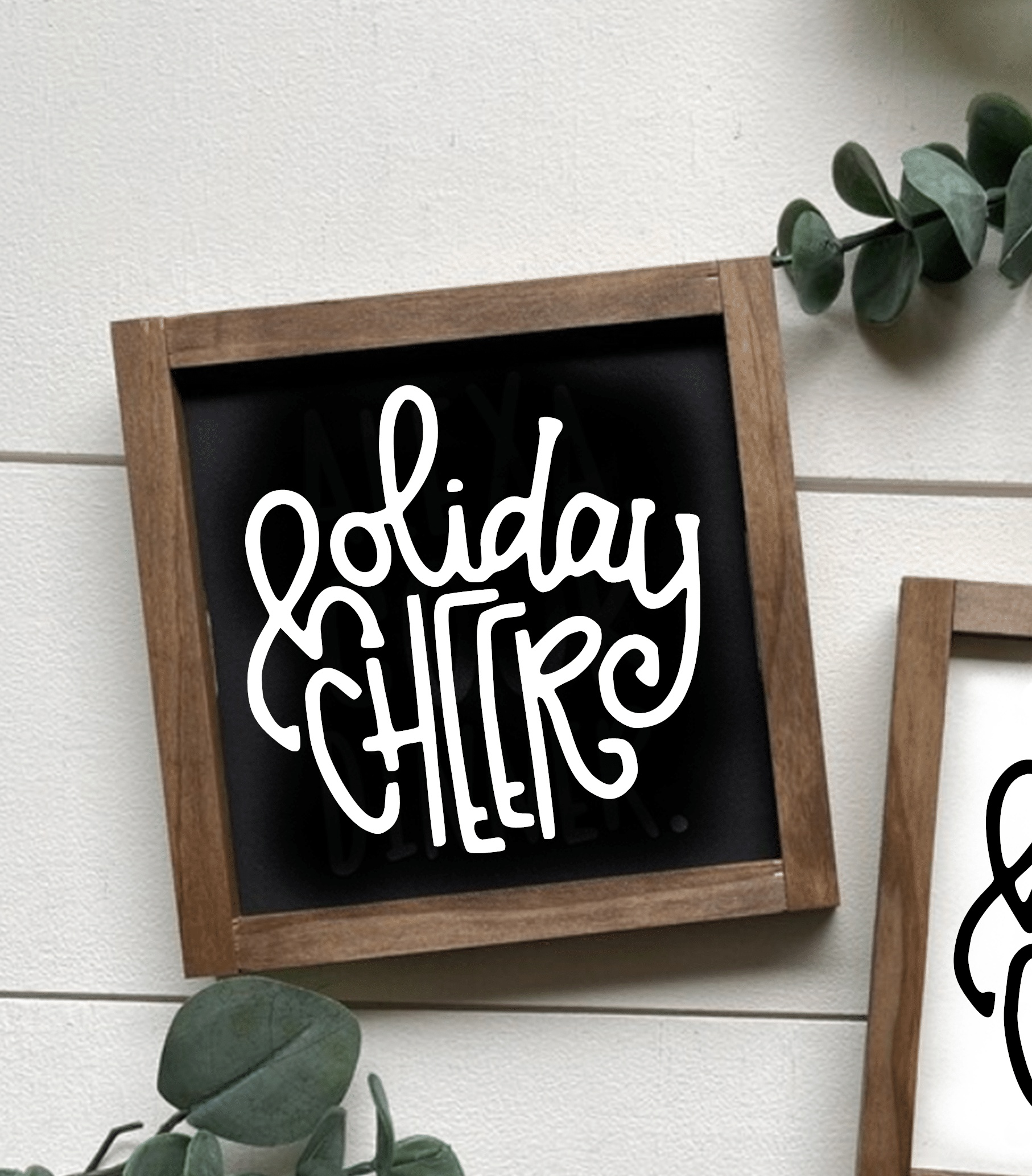 Handcrafted wooden sign with "Holiday Cheer" in white lettering on a black background, rustic wood frame.