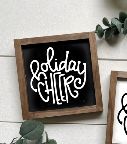 Handcrafted wooden sign with "Holiday Cheer" in white lettering on a black background, rustic wood frame.