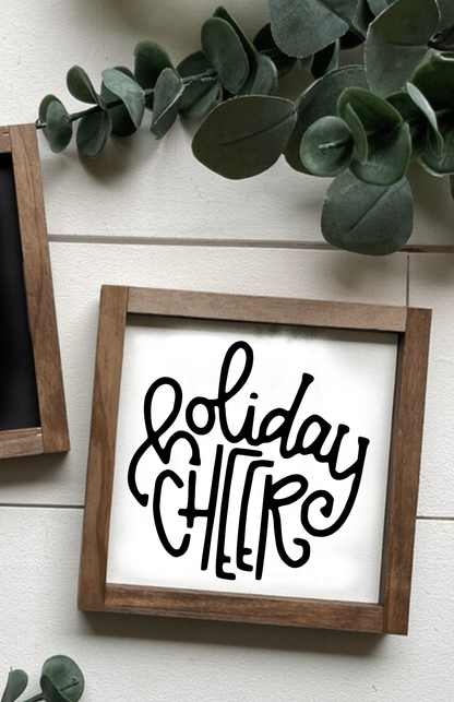 Handcrafted holiday cheer Christmas wood sign with black lettering on white background and rustic wooden frame.