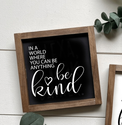 Framed wood sign with "In a World where you can be Anything Be Kind" message on black background with white lettering.