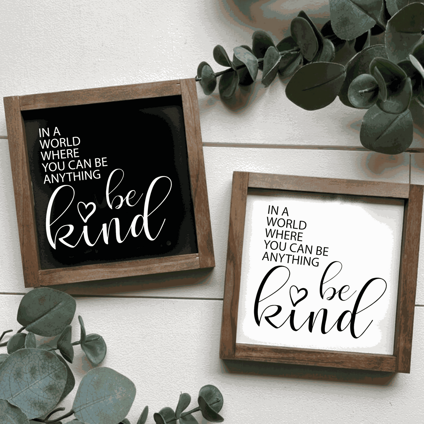 Framed wood signs with "In a World where you can be Anything Be Kind" message, in black and white backgrounds.