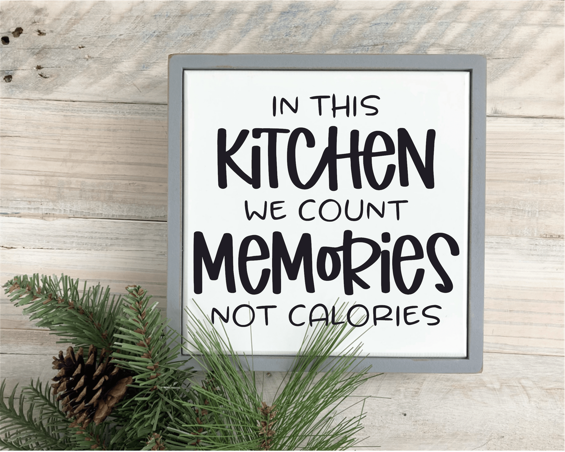 Framed wood sign with "In This Kitchen We Count Memories not Calories" text on white background with black lettering.