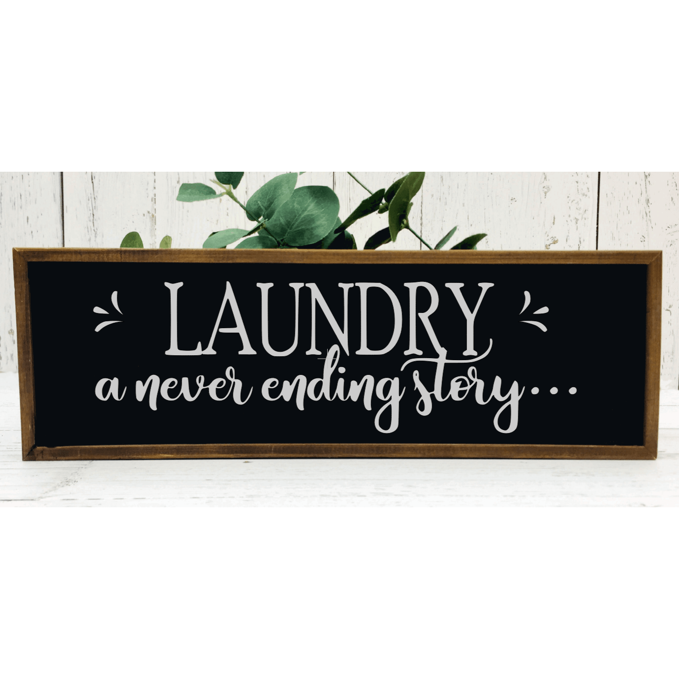 Laundry a never ending story wood framed sign with black background and white lettering