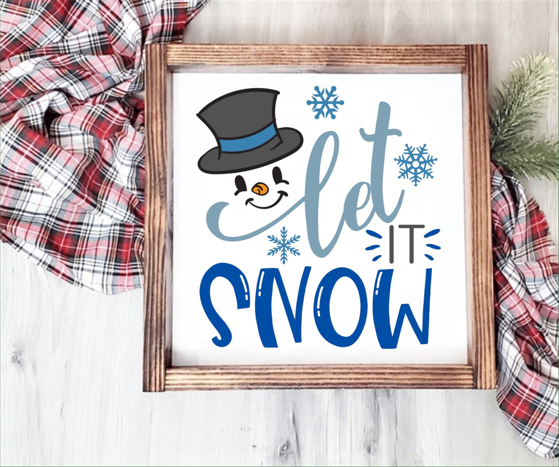 Handcrafted "Let it Snow" wood sign with a smiling snowman design and snowflakes, framed with stained wood.