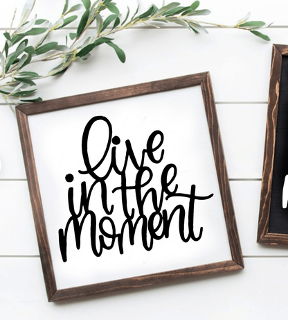 Handcrafted "Live in the Moment" wood sign with black script on white background, framed in wood.