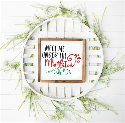 Handmade "Meet Me Under the Mistletoe" wood framed sign with festive decor.