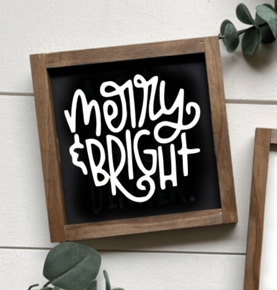 Handmade wood sign with "Merry & Bright" text, framed in rustic pine.