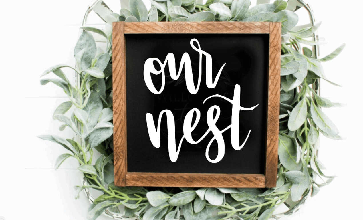 Handcrafted "Our Nest" framed wood sign with black background and white lettering.