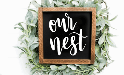 Handcrafted "Our Nest" framed wood sign with black background and white lettering.