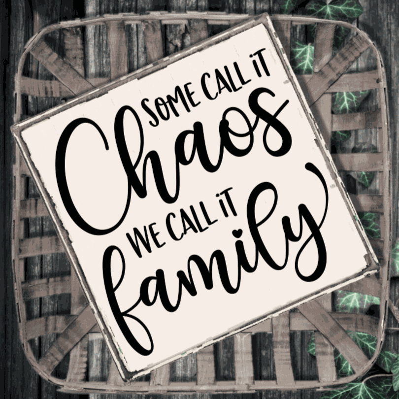 Handmade wood sign with "Some Call it Chaos, We Call it Family" phrase in black lettering on a white background.