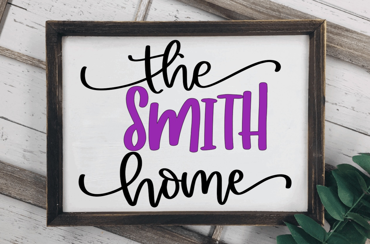 Framed wood family name sign with personalized purple and black lettering on a white background.