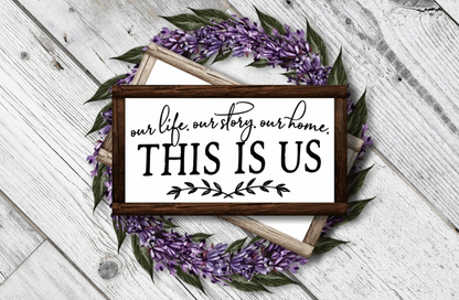 Framed farmhouse wood sign with "This is Us" lettering, stained frame, lavender wreath, white background.