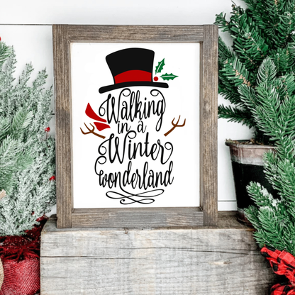 Festive snowman sign with "Walking in a Winter Wonderland" text, top hat, and red scarf on a wood frame.