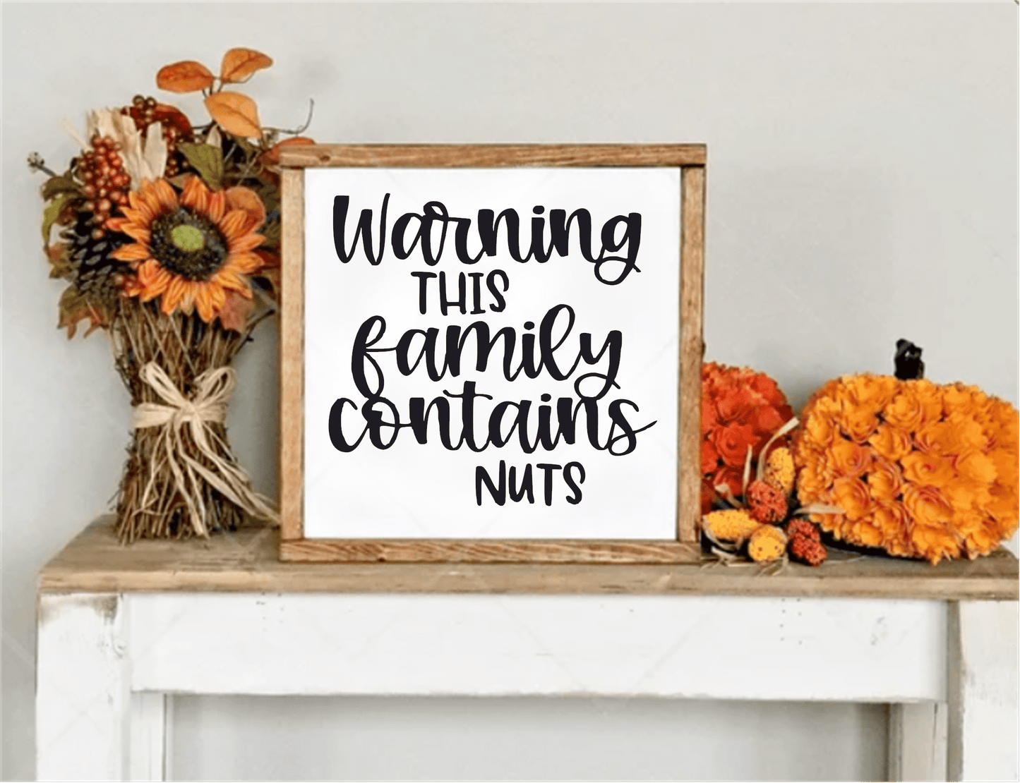Funny handcrafted wood sign with "Warning This Family Contains Nuts" text, framed in natural wood. Perfect for home decor or as a unique gift.
