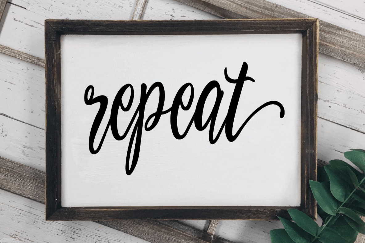 Rustic wood laundry room sign with "repeat" text and stained frame.