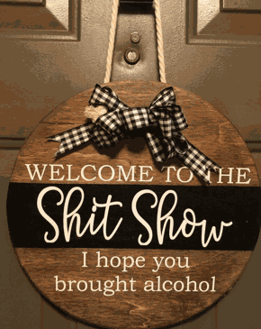 Humorous round wooden door sign with "Welcome to the Shit Show", customizable size and color options.