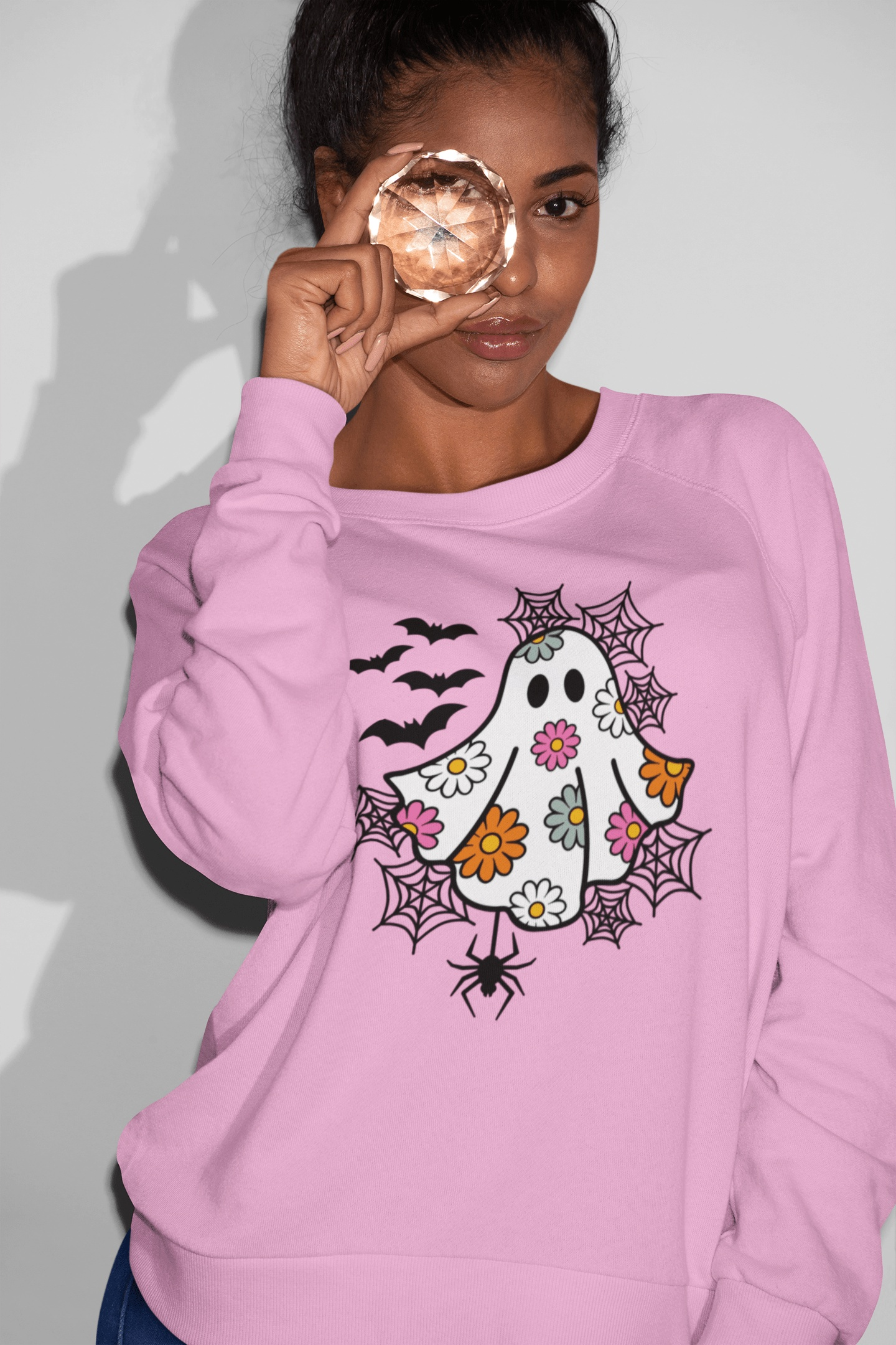 Women's Spooky Daisy Ghost Sweatshirt with Halloween design in pink.