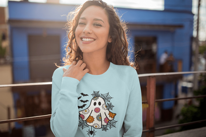 Smiling woman wearing a blue Halloween sweatshirt with colorful ghost and daisy design.