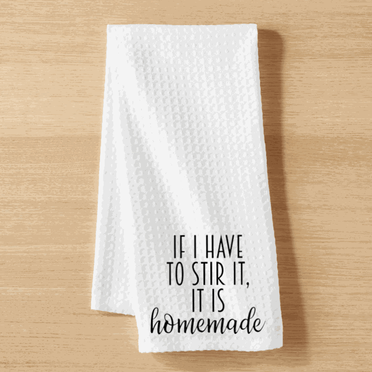 White microfiber tea towel with "If I have to Stir it, it is Homemade" text, waffle weave design, 16x24 inches.
