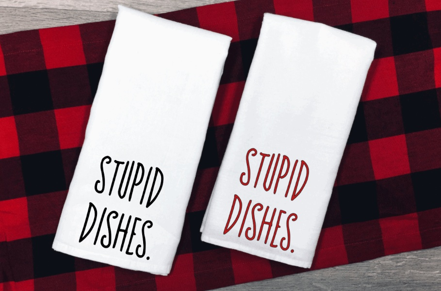 White microfiber tea towels with "Stupid Dishes" slogan on red and black checkered background.