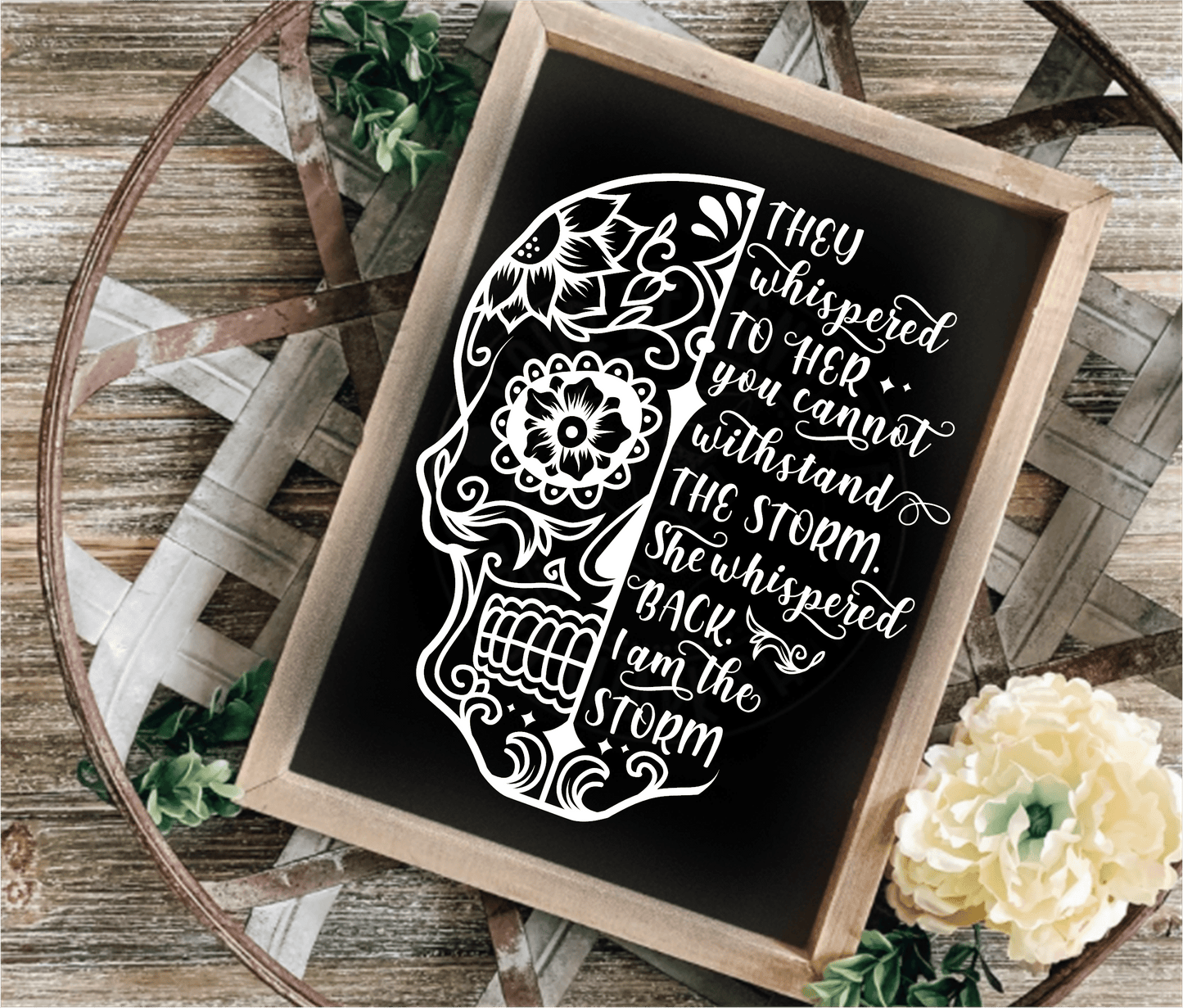 Inspirational wood frame sign with floral skull design and motivational quote on black background.