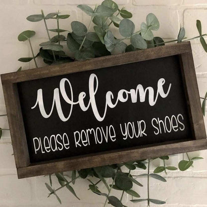 Handmade wood sign with "Welcome Please Remove Your Shoes" text in black and white, featuring a stained frame, perfect for entryway decor.