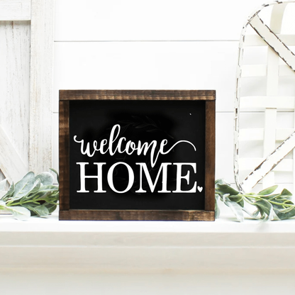 Handmade "Welcome Home" framed wood sign with dark wooden frame and customizable rustic finish.